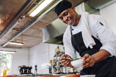 A student chef prepares a meal in a profesional kitchen